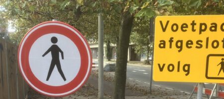 Deze afbeelding toont een omleidingsbord bij een afgesloten voetpad.
